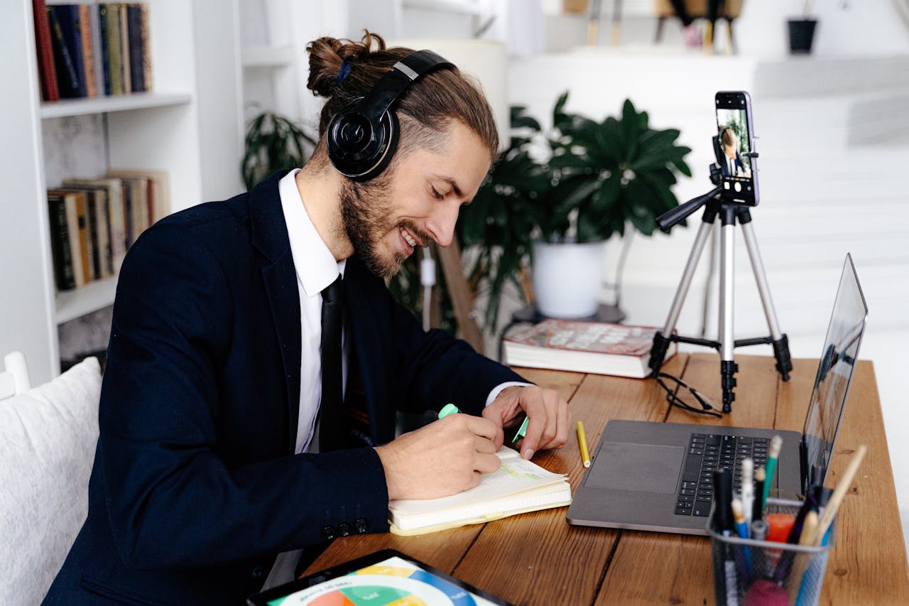 Man in headphones enjoying creative work and study session at home while video conferencing.