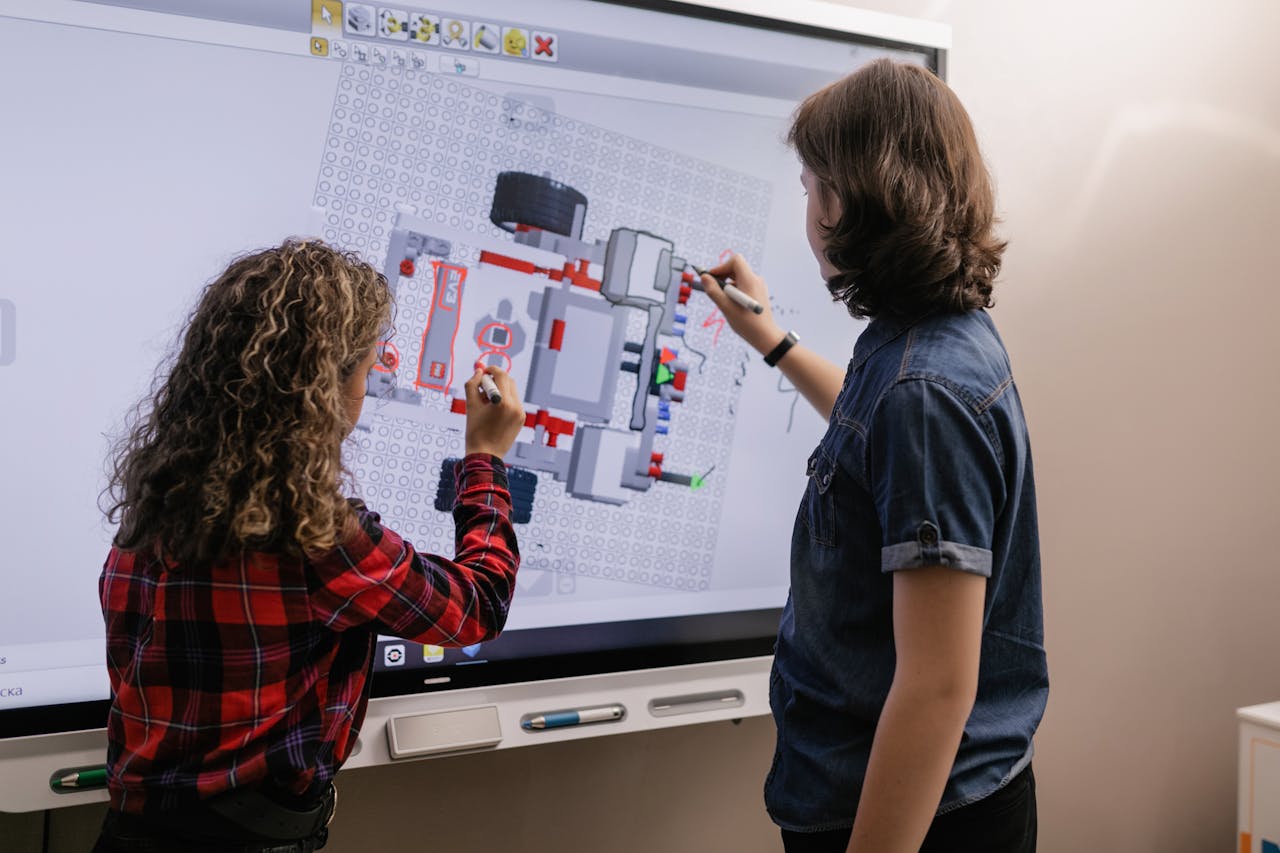 Mastering the First Impression: Your intriguing post title goes here Two children engaging with a smart board in a modern classroom setting.
